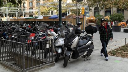 Un hombre camina entre motos y un alcorque, en la plaza de la Catedral de Barcelona, este viernes.