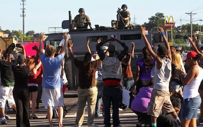 Manifestantes ante un veh&iacute;culo blindado de la polic&iacute;a en Ferguson, Misuri
