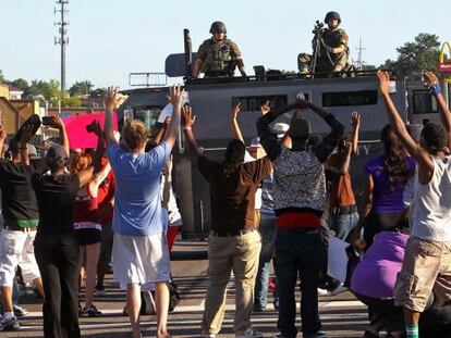 Manifestantes ante un veh&iacute;culo blindado de la polic&iacute;a en Ferguson, Misuri