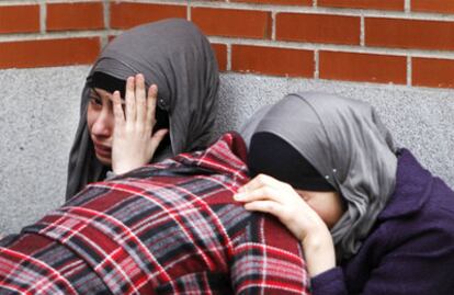 Tres mujeres lloran a las puertas de la casa donde ha sido asesinada la mujer.