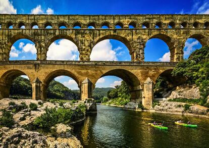 Piragüistas pasando bajo el Pont du Gard, cerca de Nimes (Francia).