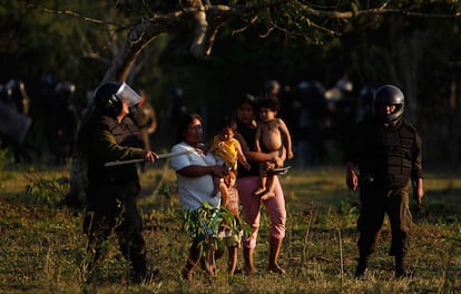 La policía conduce a una mujer y a unos niños tras los choques entra los antidisturbios y los manifestantes a las afueras de Yucumo.