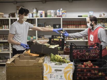 La Ong de Vei a vei organiza una red solidaria de distribuición de comida a personas con pocos recursos en el Barrio de Sant Antoni, en Barcelona. En la imagen Alvaro y Pol, dos voluntarios de la ONG, organizan el almacén en la sede de la Calle Rocafort.