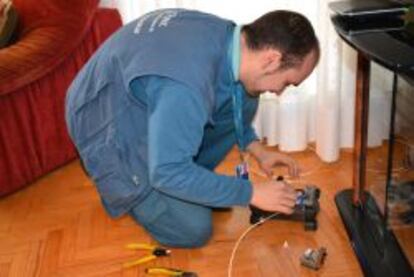 Un técnico de una empresa colaboradora de Telefónica instala los servicios de fibra óptica en una casa.