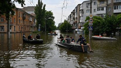 Voluntarios en un bote durante la evacuación de residentes locales de una zona inundada en Jersón