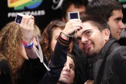 Juanes se fotografía junto a fans a la entrada de los premios.