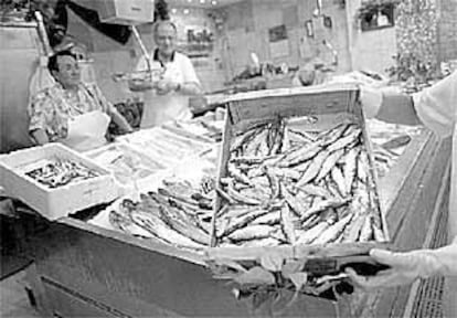 Una pescadera del mercado de La Bretxa muestra una caja de sardinas.