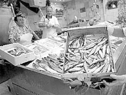 Una pescadera del mercado de La Bretxa muestra una caja de sardinas.