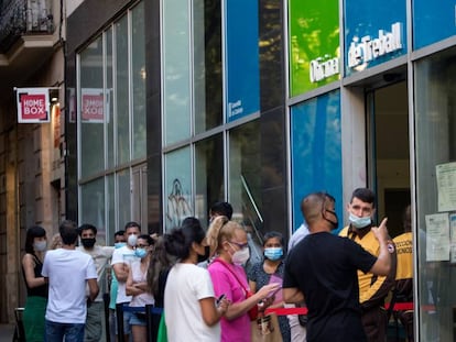Personas con mascarilla, hacen cola en la Oficina de Treball de la Generalitat.