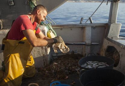 Tripulante del pesquero Caleta Vélez (Málaga), retirando plástico de una de sus capturas.