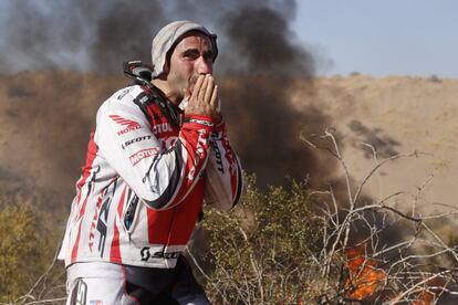 Goncalves se lamenta ante el humo de su moto incendiada tras el accidente sufrido en la quinta etapa del Dakar.