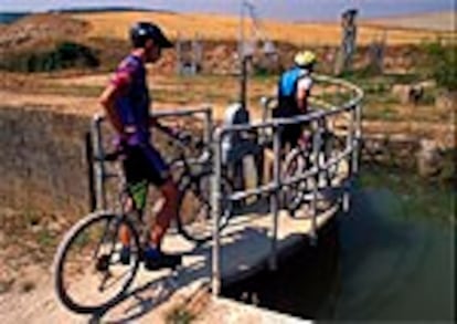 Dos ciclistas cruzan una de las esclusas del ramal sur.