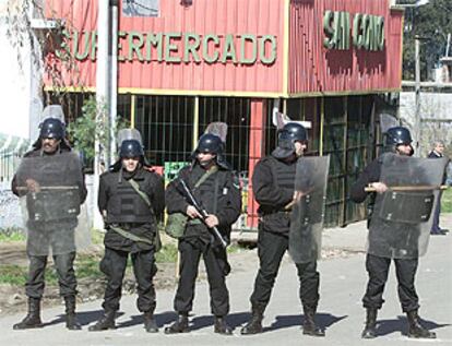 La policía uruguaya protegía ayer la entrada a un supermercado para evitar más saqueos.