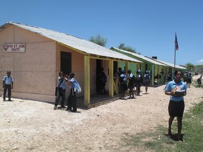 Una profesora pasa delante de una de las aulas construidas por los jesuitas en Canaán.