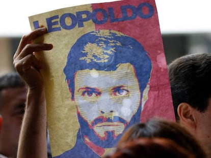 Un partidario de Leopoldo L&oacute;pez muestra un cartel con su rostro a las puertas de un tribunal de Caracas, el 20 de junio.