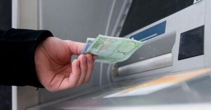 Un hombre saca euros de un cajero automático.