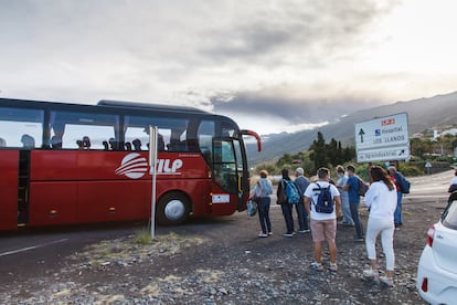 Varias personas hacen cola este sábado para subir a un autobús para turistas que se dirige a la iglesia de Tajuya desde el aeropuerto viejo de Buenavista.