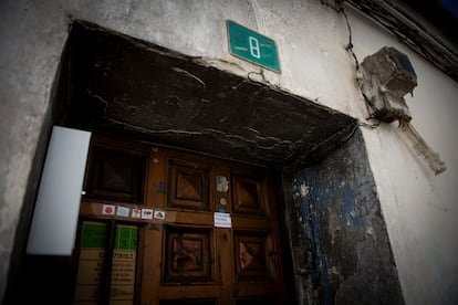 Restos del incendio en el quicio de la puerta, con una pegatina con insultos. 