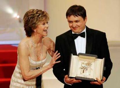 El director rumano Cristian Mungiu recibe la Palma de Oro de manos de la actriz Jane Fonda.