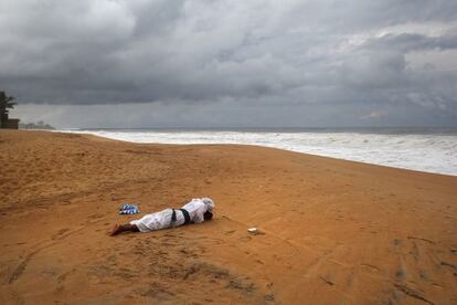 Un miembro de una iglesia evangelista reza en la playa de Monrovia en una ceremonia en la que piden a Dios que rescate a su pa&iacute;s, Liberia, de esta crisis profunda.