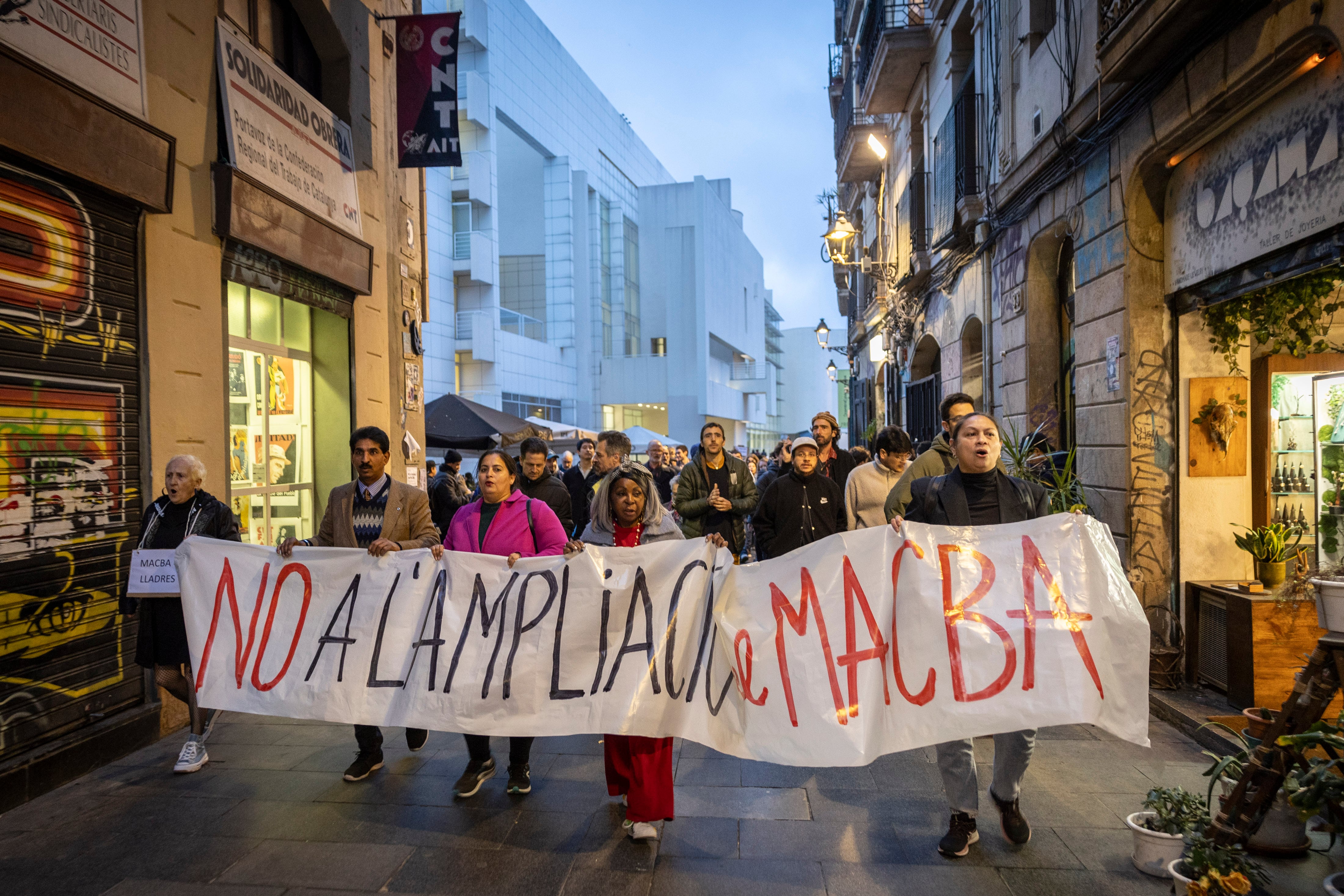 Vecinos y patinadores del Raval durante una manifestación por la ampliación del Macba, al fondo de la imagen, en 2024.