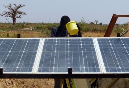 Un joven bebe agua del pozo que gestiona un sistema de riego alimentado con energía solar de la granja familiar de Mang Ndour, situada en Ndianda, en la comunidad rural de Nguéniène.