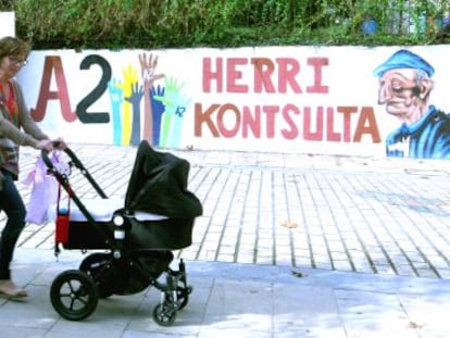 Dos mujeres pasan junto al mural hecho para la consulta popular en la plaza de Arrankudiaga.