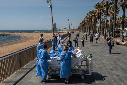 Personal sanitario del hospital del Mar de Barcelona, lleva a un paciente de covid-19 a la playa como parte de un programa para humanizar las UCI.