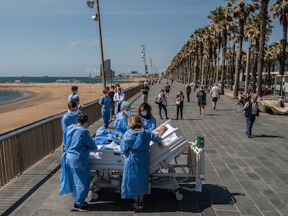 Personal sanitario del hospital del Mar de Barcelona, lleva a un paciente de covid-19 a la playa como parte de un programa para humanizar las UCI.