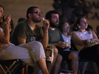 Varias personas comen durante una proyección al aire libre en Barcelona.