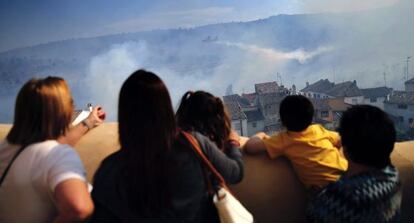 Vecinos de Chelva contemplan el incendio declarado en la vecina Calles y que ha afectado a ambos términos municipales.