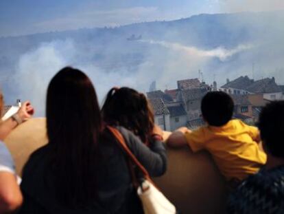 Vecinos de Chelva contemplan el incendio declarado en la vecina Calles y que ha afectado a ambos términos municipales.