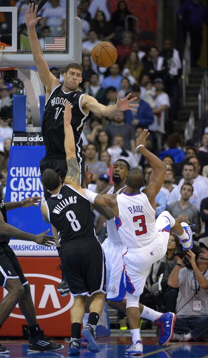 Brook Lopez, de los Nets, se eleva sobre su compañero Deron Williams para taponar el tiro de Paul, de los Clippers.