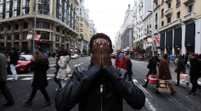 Yafar shields his face on a Madrid street.