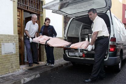 Trabajadores de la funeraria retiran el cuerpo de Clara, de 42 años, tras ser apuñalada por su marido en Telde.