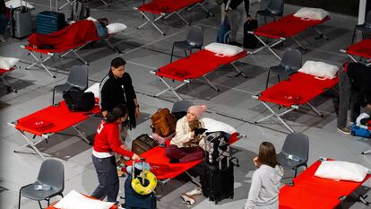 Una familia se acomoda en el las camas montadas por Cruz Roja en el IFEZA (Institución Ferial de Zamora)