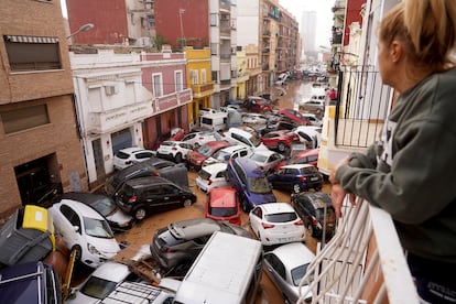 EL PAÍS abría hoy jueves 31 de octubre su edición impresa con esta imagen, una de las fotos más impactantes del municipio de Sedaví. En ella, una vecina asomada a un balcón observa la imposible maraña de vehículos.
