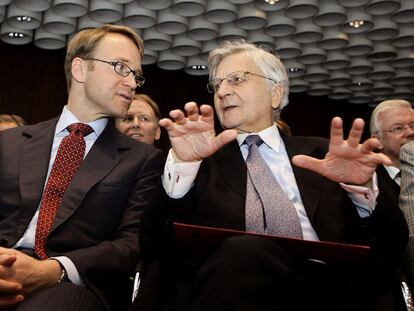 Weidmann (izquierda) conversa con Trichet en la toma de posesión del primero, ayer en Fráncfort.