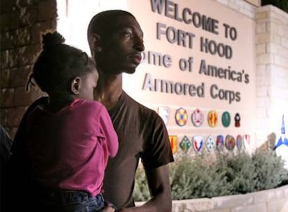 Un militar con su hija espera a su esposa, también soldado, en la entrada principal de Fort Hood.