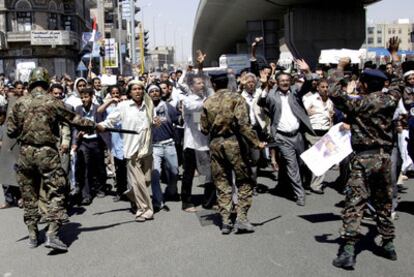 La policía intenta contener a unos manifestantes que marchaban hacia el palacio presidencial de Saná.