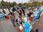 Health workers take swabs from residents to be tested for the COVID-19 coronavirus as part of a mass testing program following a new outbreak of the coronavirus in Qingdao, in China's eastern Shandong province on October 13, 2020. (Photo by STR / AFP) / China OUT