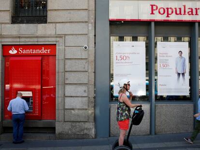Varias personas pasan por delante de una sucursal del Banco Popular en Madrid.