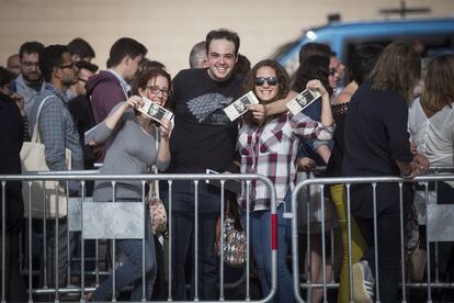 Espectadors que van acudir al recital mostren la seva entrada a les portes del Palau Sant Jordi.