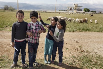 Las hermanas de Hamzeh burlándose de él, que está de pie con su primo delante de la tienda en la que vive con la familia tras huir de Siria. 