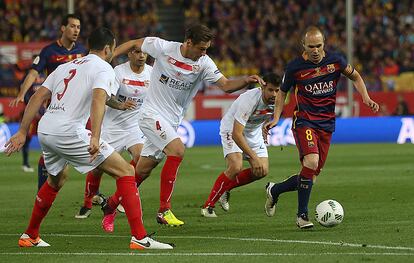 Andrés Iniesta lucha por la pelota ante los jugadores del Sevilla.