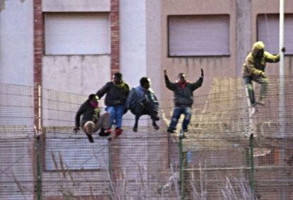 Inmigrantes saltan la valla de Melilla el pasado febrero.