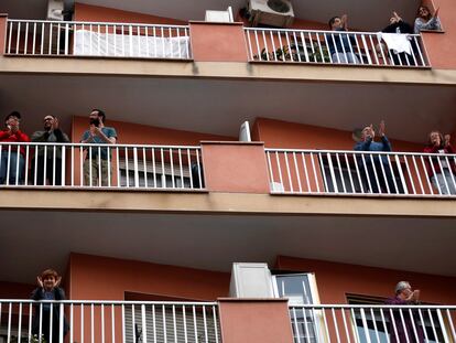 Vecinos de L'Hospitalet salen a sus balcones como cada día a animar y homenajear a los sanitarios.