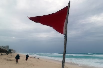 Una bandera roja en la playa que indica oleaje agitado y fuertes corrientes debido a la proximidad del huracán 'Beryl' en Cancún.