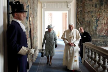 Isabel II y Benedicto XVI, seguidos del príncipe Felipe, caminan por el Palacio de Hoolyrood, en Edimburgo.