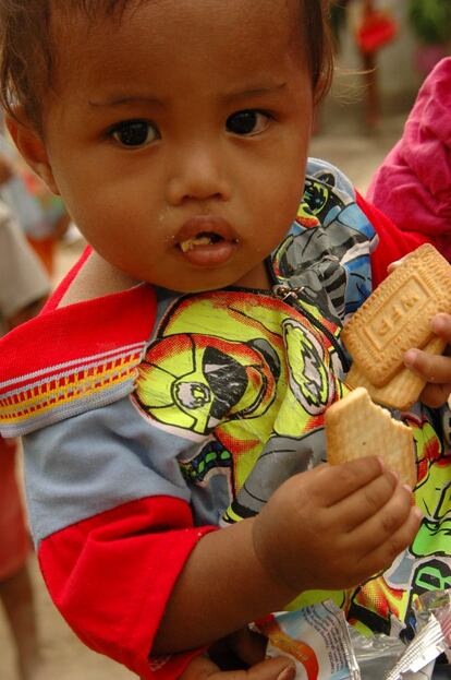 Timor Occidental, Indonesia 2008. La imagen se tomó durante una distribución de galletas enriquecidas con vitaminas y minerales en Timor Occidental, Indonesia. Como suele ocurrir en otras latitudes, a pesar de la insistencia de la madre de este niño en guardar los paquetes hasta que llegaran a su casa, el niño pudo más…